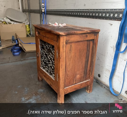 ארון עץ קטן עם דלת מתכת בתוך משאית הובלה